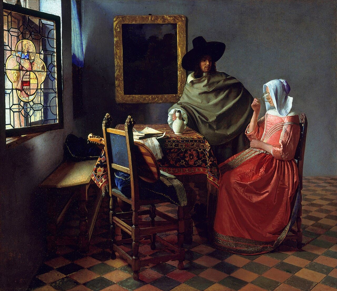 Vermeer's The Wine Glass, showing a woman seated at a table drinking wine while a standing man pours more, in a sunlit interior with a stained-glass window.